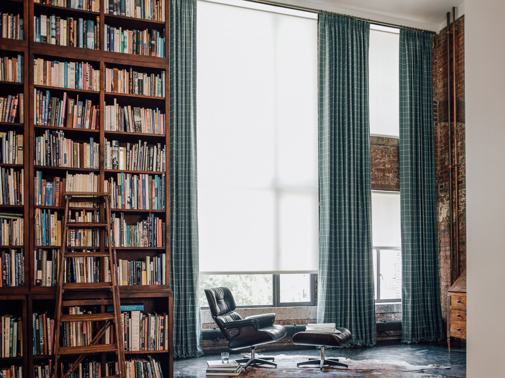 Solar shades and tailored drapery in the library. Materials featured are "1%" in white and "Highland" in cove.