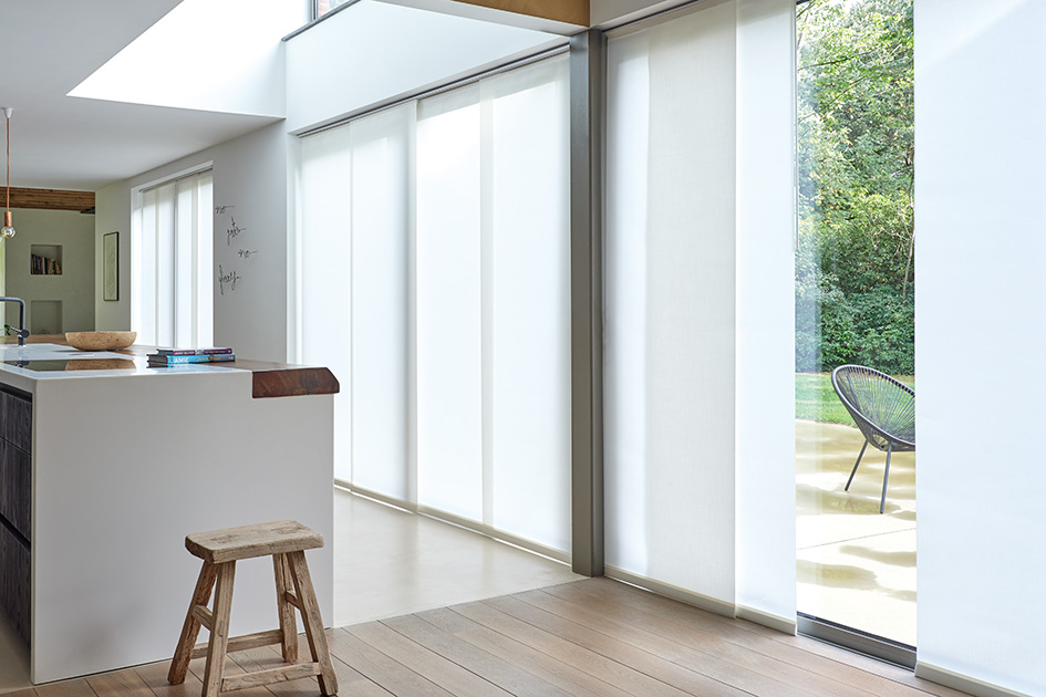 Sleek white vertical blinds are one of the types of window shades and they cover sections of glass doors