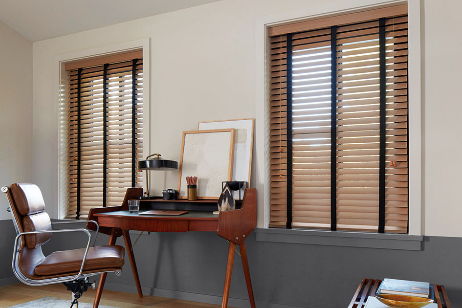 An office features inside mount wood blinds with black tape showing why you would choose inside vs outside mount blinds