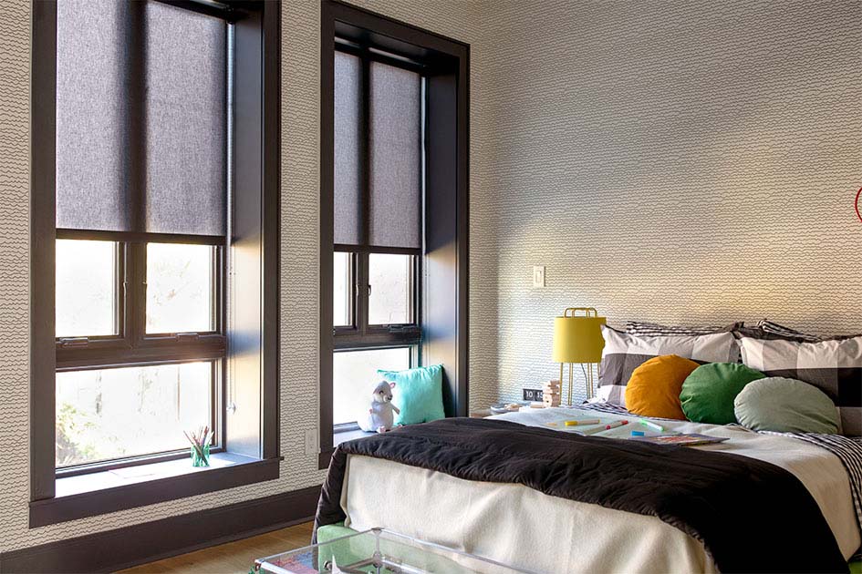 A bedroom with tall black-framed windows features inside mount shades, showing why choose inside vs outside mount blinds