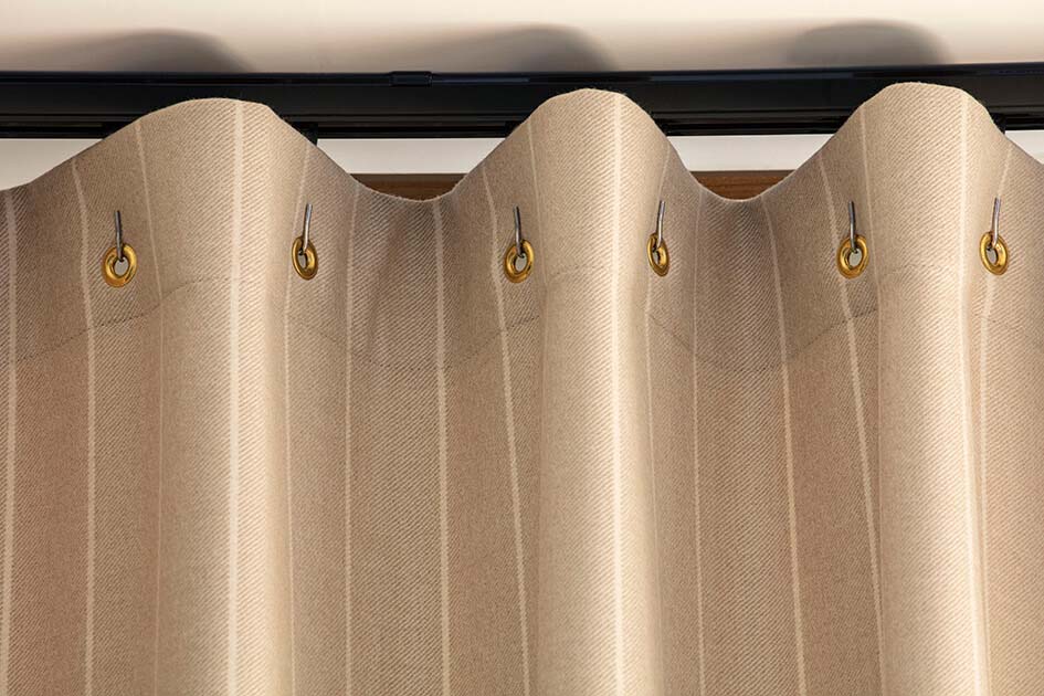 A close up of cubicle drapery wth gold fabric shows how drapery is an alternative to shades for sliding glass doors