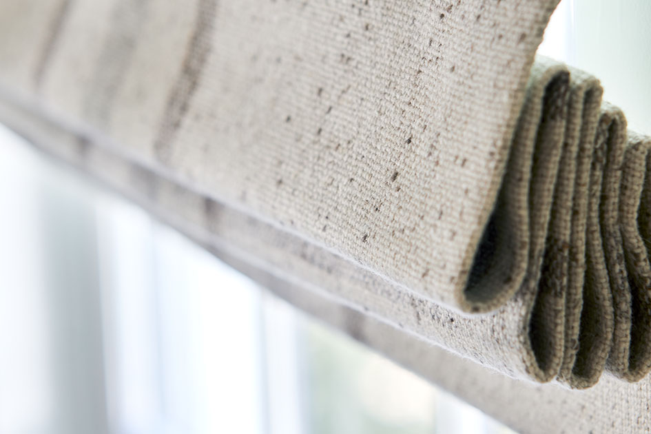 A close up image of a flat roman shade in Aberdeen Oat shows how stack affects shades for sliding glass doors