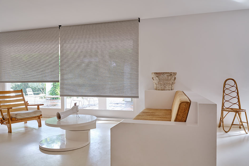 A living room with scandinavian inspired design and decor features reverse roll roller shades in mesa verde mist