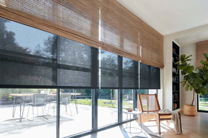 Mid century modern window treatments include light waterfall woven wood shades layered with black 5% solar shades