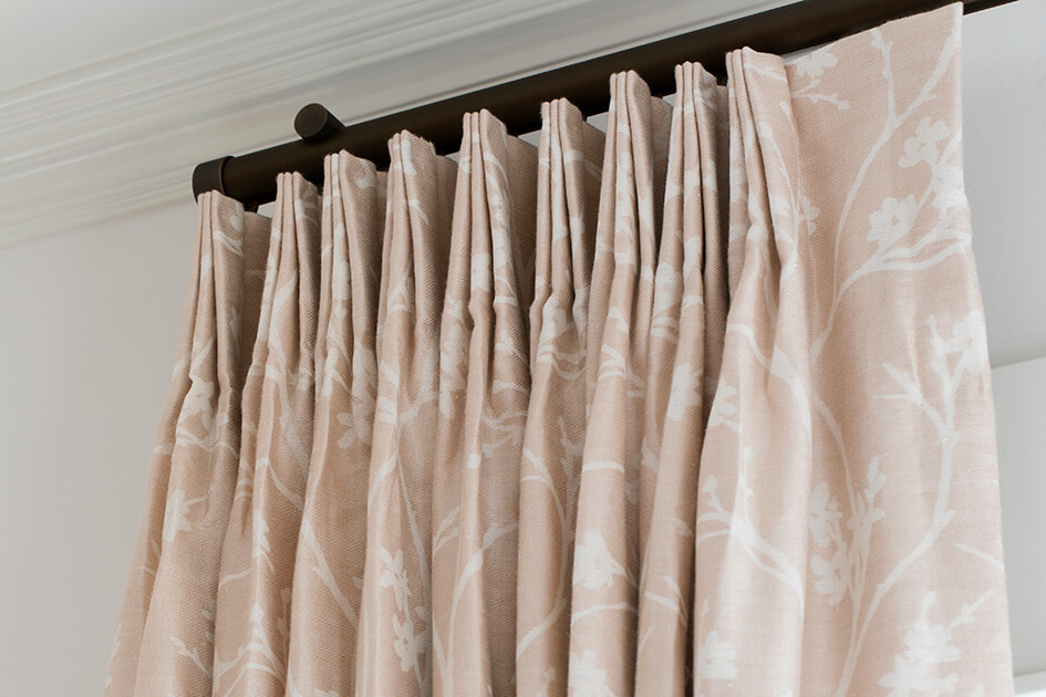 A close up of tailored pleat drapery in a pink color shows an alternative to shades for sliding glass doors