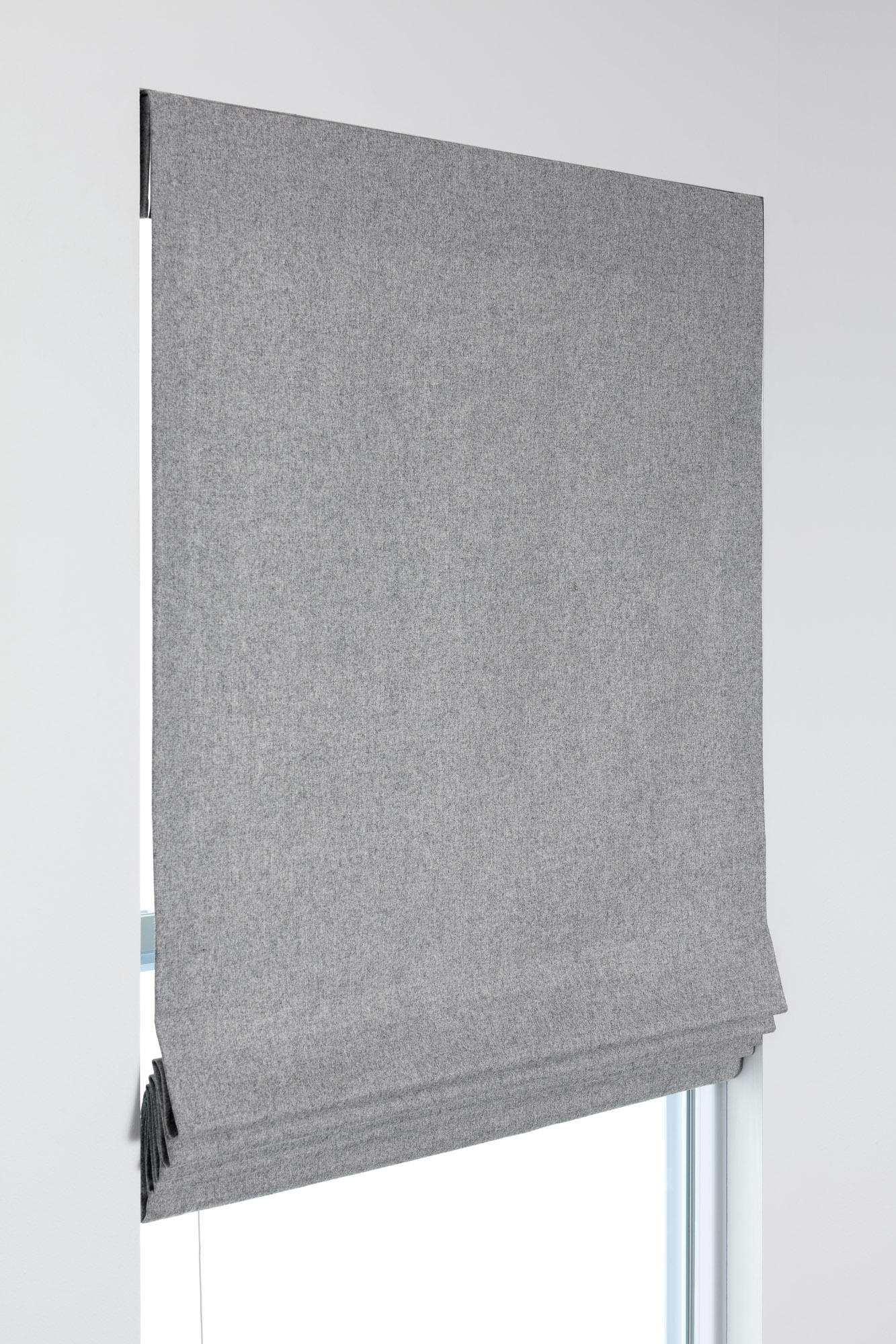 Flat Roman Shade example in gray fabric raised part way, showing a smooth face and clean fold at the bottom.