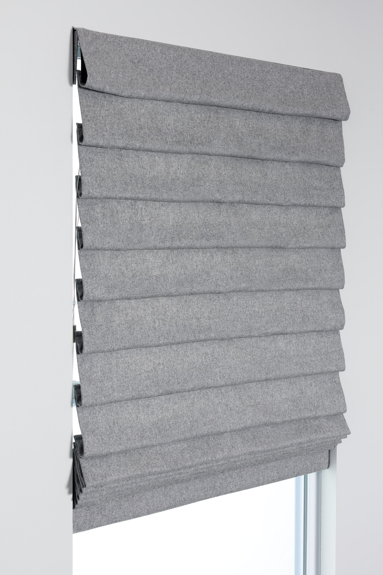 Pleated Roman Shade style in gray fabric with full hobbled folds, shown mounted above a window for a layered look.