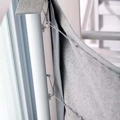 A close-up of the back of a cordless roman shade shows the tension mechanism that explains how do cordless blinds work