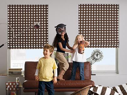Cordless Roman Shades in a kids play room with children jumping on a futon and playing