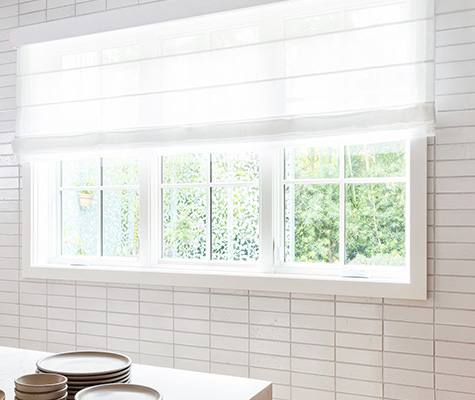 Roman Shades for kitchen windows include Aventura Roman Shades of Lannister Sheer in White in a bright white tiled kitchen