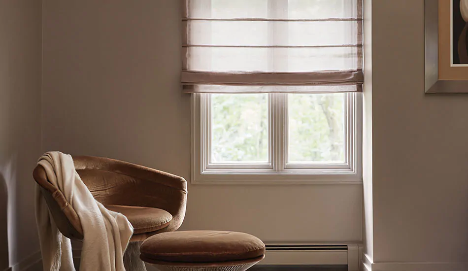 A small nook features warm tones and a window with an Aventura Roman Shade made of light filtering Sheer Elegance in Cocoa