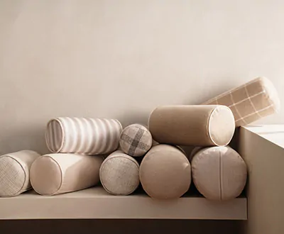 Bolster pillows in warm tan fabrics with plaid patterns show the possibilities for window seat ideas