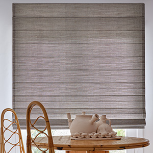 A Cascade Woven Wood Shade made of Jackson in Sun adds texture to a mid-century modern dining room with a wood dining set