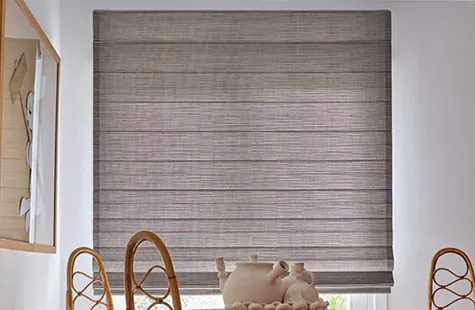 A mid-century modern dining room with a wood dining set features woven window shades made from Jackson material in Sun