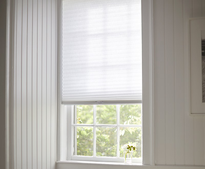 A Cordless Single Cell Cellular Shade in Light Filtering Lace in a soft white room shows one style of pull down window shades