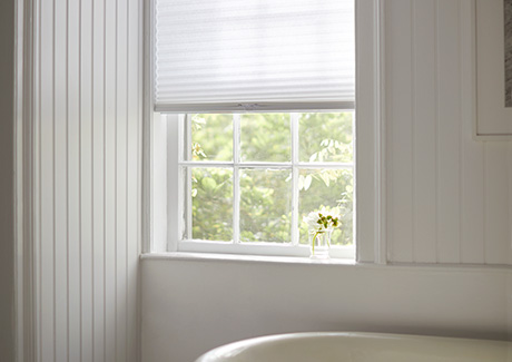 To answer what are cellular shades, an image of a cellular shade of single cell material in Lace adorns a bathroom window
