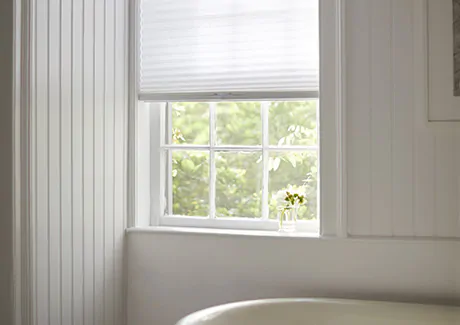 To answer what are cellular shades, an image of a cellular shade of single cell material in Lace adorns a bathroom window