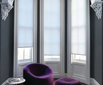 Window treatments for bay windows include Cellular Shades made of single cell light filtering material in Sky
