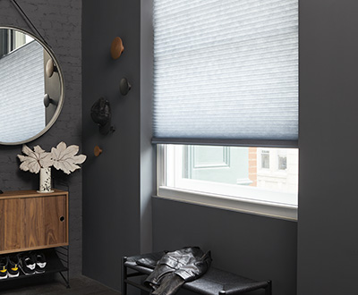 A foyer features light-filtering Cellular Shades with their pleated design that shows the difference between blinds vs shades