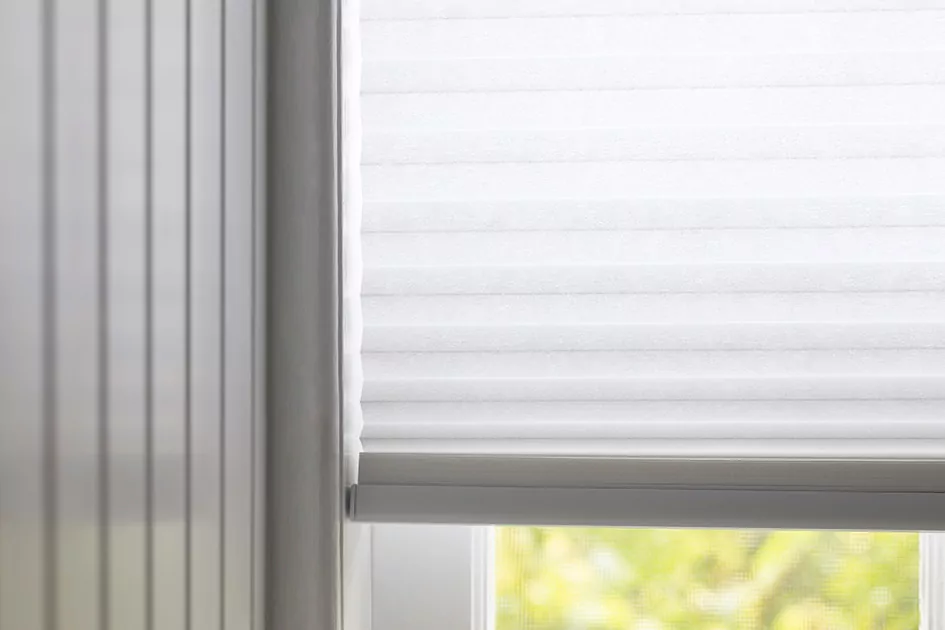 A close up of light filtering white cellular shades shows one option for shades for sliding glass doors