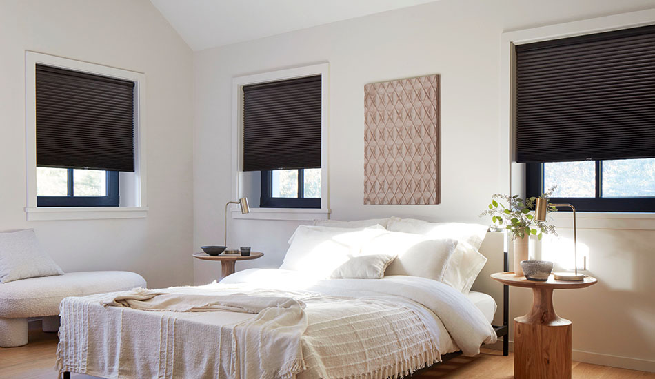 Window coverings in a modern, boho bedroom include Cellular Shades made of Single Cell Blackout material in Midnight