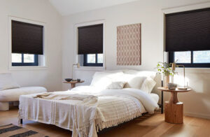 Windows shades in a modern boho bedroom include Cellular Shades made of single cell blackout material in Midnight