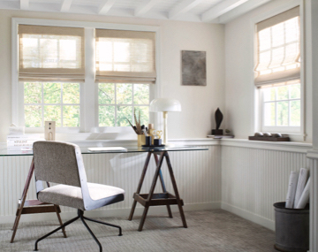 Framed windows featuring Cordless Roman Shades in an office with white walls, glass desk and grey chair