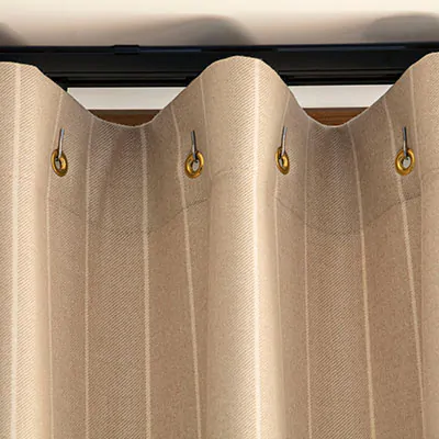 A close up of Cubicle Drapery made of Dashing Stripe in Palomino shows a gentle wave of fabric in a warm gold color