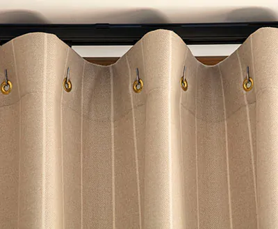 A close up of Cubicle Drapery panels made of Dashing Stripe in Palomino shows small grommets that create a gentle fabric wave