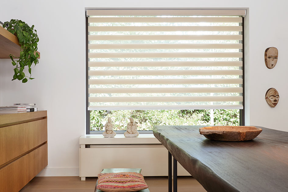 Mid century modern blinds include beige double roller shades in a dining room with a rustic wood dining table