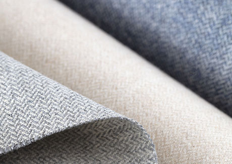Product shot of fabric for thermal curtains, focusing on synthetic fabrics in multiple colors such as blue, white and grey