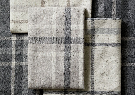 A close-up shot of a pile of swatches for plaid curtains in different colors that illustrates their impeccable design