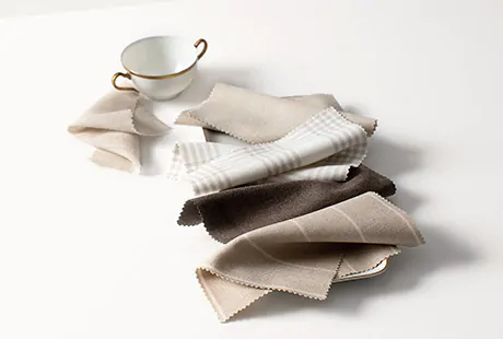 Drapery swatches from the Holland and Sherry Designer Collection have warm grey and beige tones and lay next to a teacup
