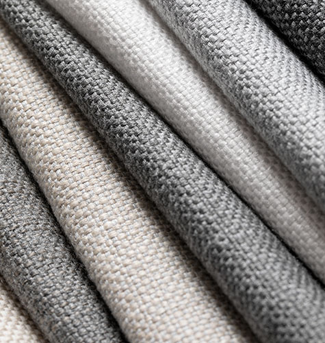 A pile of swatches made of Sunbrella Alma shows the soft texture and neutral colors of this OEKO-Tex certified material