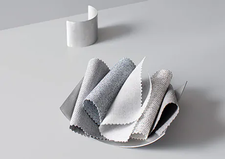 Drapery swatches from the Sunbrella Design Collection all feature cool grey tones and are piled decoratively in a silver bowl