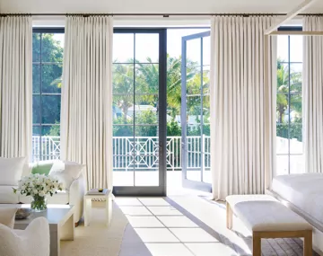 Tailored Pleat Drapery in Petal Pearl hung floor to ceiling over large patio doors in a bedroom with neutral furniture
