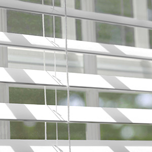 A close up of Faux Wood Blinds made of 2-inch Faux in Blanc shows how the slats offer great bathroom window privacy