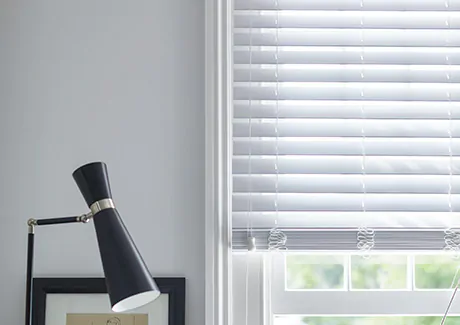 Faux Wood Blinds in Blanc in a white room feature a rigid linear design showing the difference between blinds vs curtains