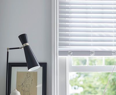 Cordless Faux Wood Blinds in Blanc in a white room with black decor shows an alternative style of pull down window shades