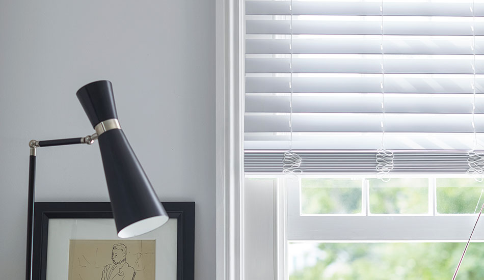 Types of blinds include 2-inch Faux Wood Blinds made of 2-inch Faux in Blanc in a white room with black accents