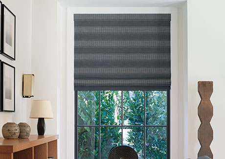 A modern space with wood decor features a Flat Roman Shade made of Jasmine in Midnight, an example of how to install Roman Shades inside mount