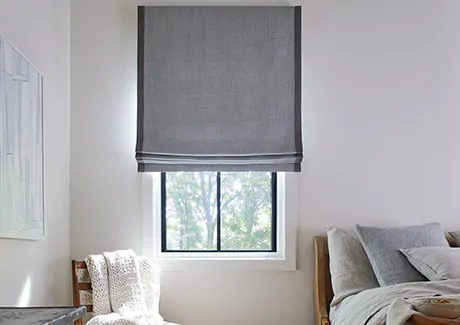 A Roman Shades has crisp folds of fabric at the bottom, showing the style difference between roller shades vs roman shades