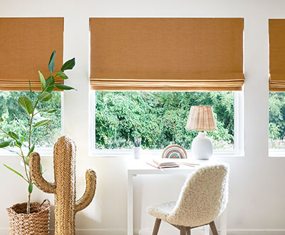 Window shades in a girl's bedroom include Flat Roman Shades made of Lisbon Woven in Bronze for a bright, inviting look
