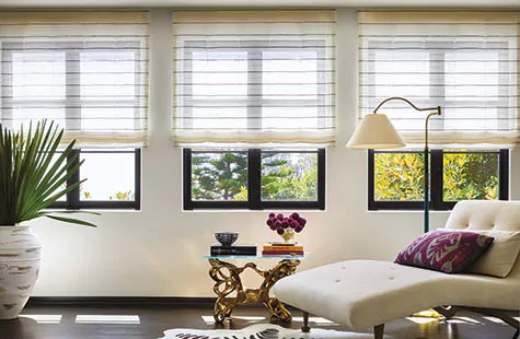 To compare light filtering vs blackout a lounge shows the soft light filtering by Flat Roman Shades of Sahara Stripe, Onyx
