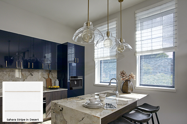 An urban modern kitchen has blue cabinets and Roman Shades for kitchen windows made of Sahara Stripe in Onyx