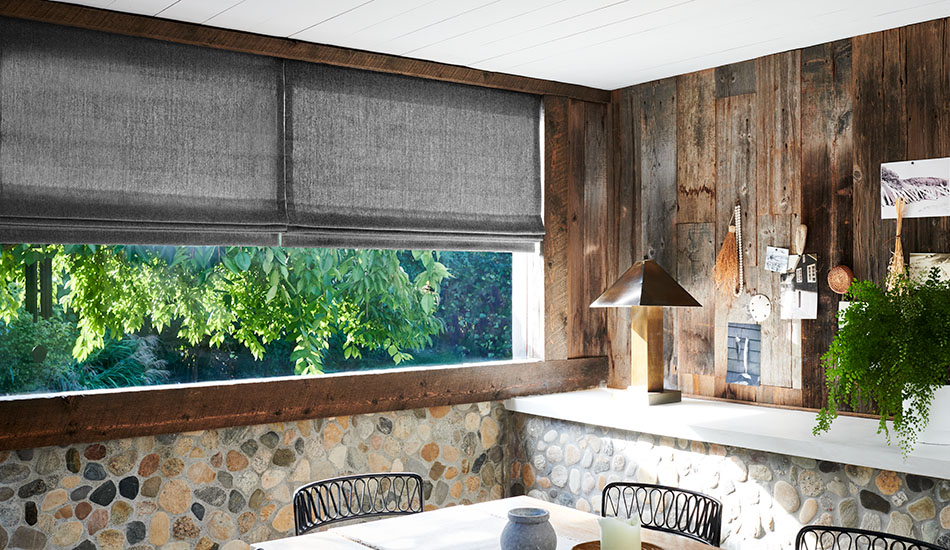 Window coverings in a earthy, rustic dining room include Flat Roman Shades made of Lowell Tweed in Flint