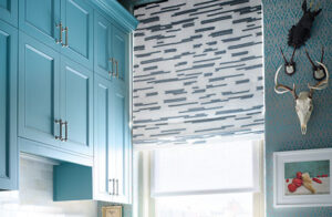 Roman Shades for windows include Flat Roman Shades made of Archer in Lagoon in a kitchen with turquoise blue cabinets