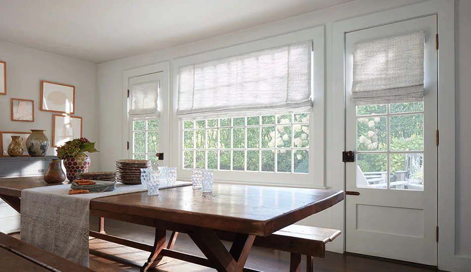 A dining room chose roman shades when comparing roller shades vs roman shades for its elegant folds of fabric