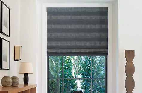 A dark Roman Shades made of Jasmine in Midnight offers lots of texture and dimension to a window in a modern room