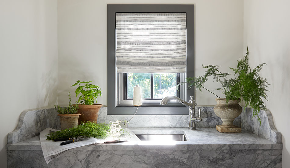 Off-white walls and a light Flat Roman Shades made of Tidal Line in Slate show how to brighten a dark room with light colors